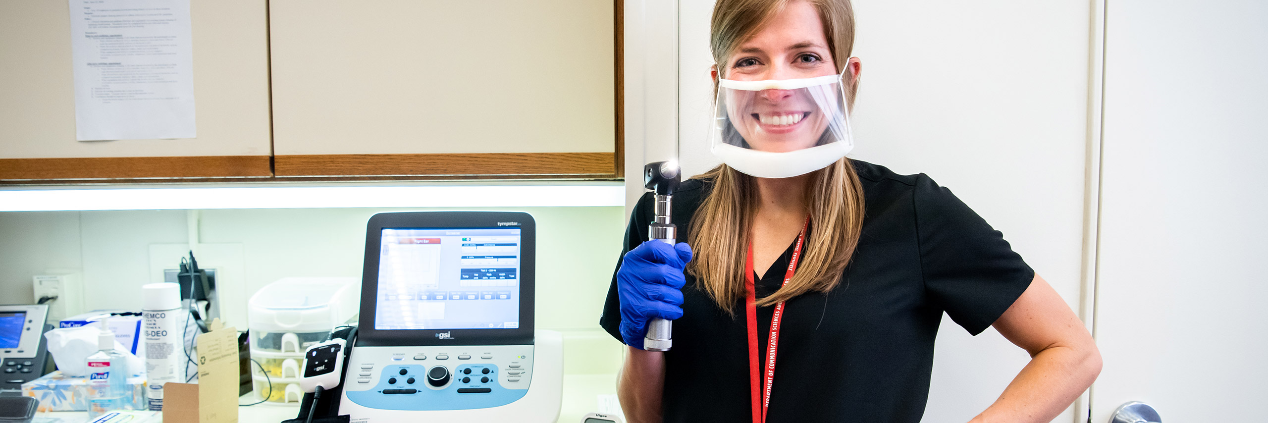 Female researcher utilizing medical equipment for communication science and disorder research in a clinical setting.